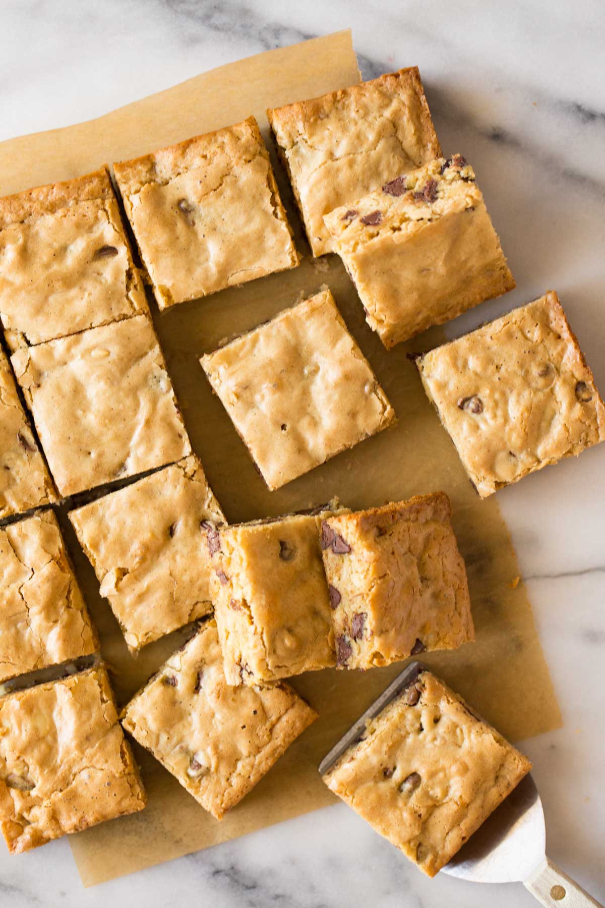 Overhead view of Easy One Bowl Blondies cut into squares on a white marble background. 