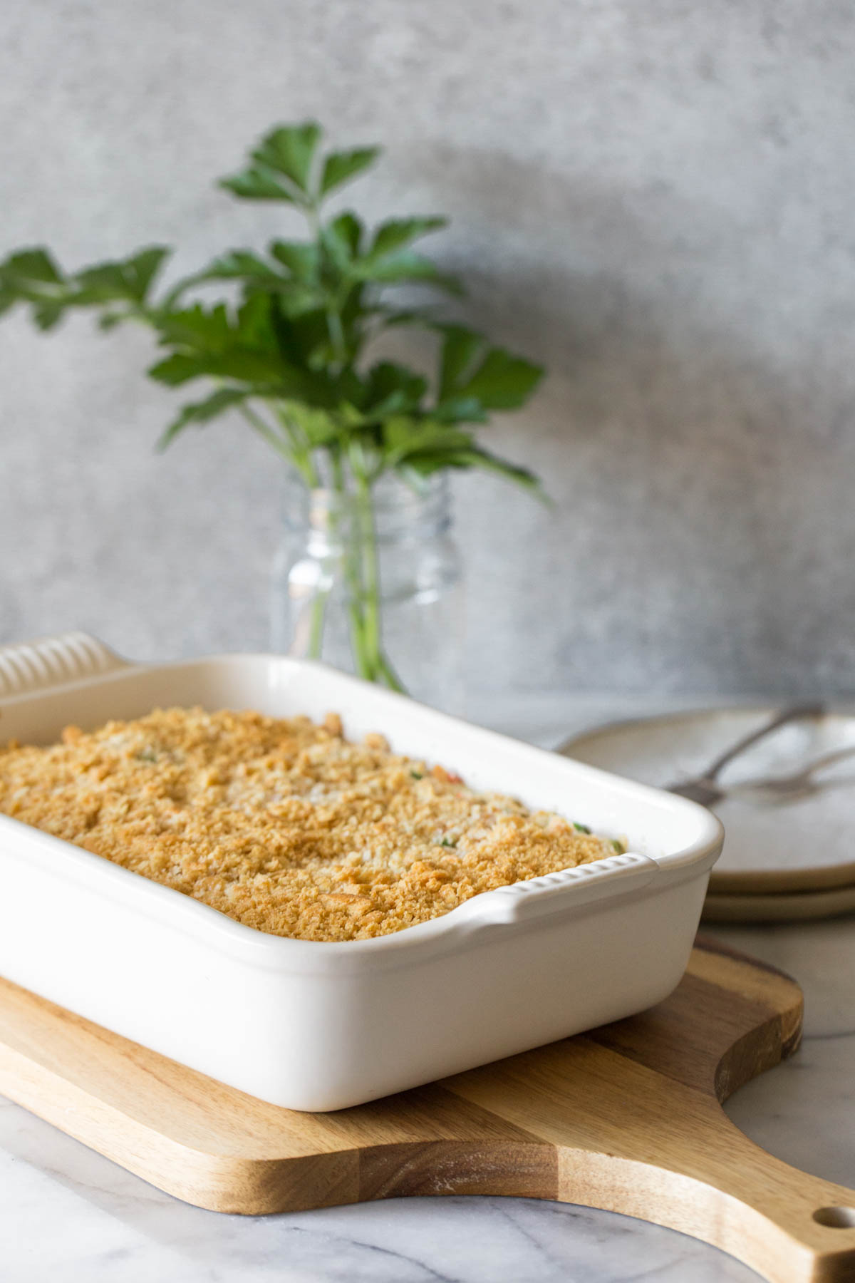 Cooking casserole dish on a wooden cutting board. 