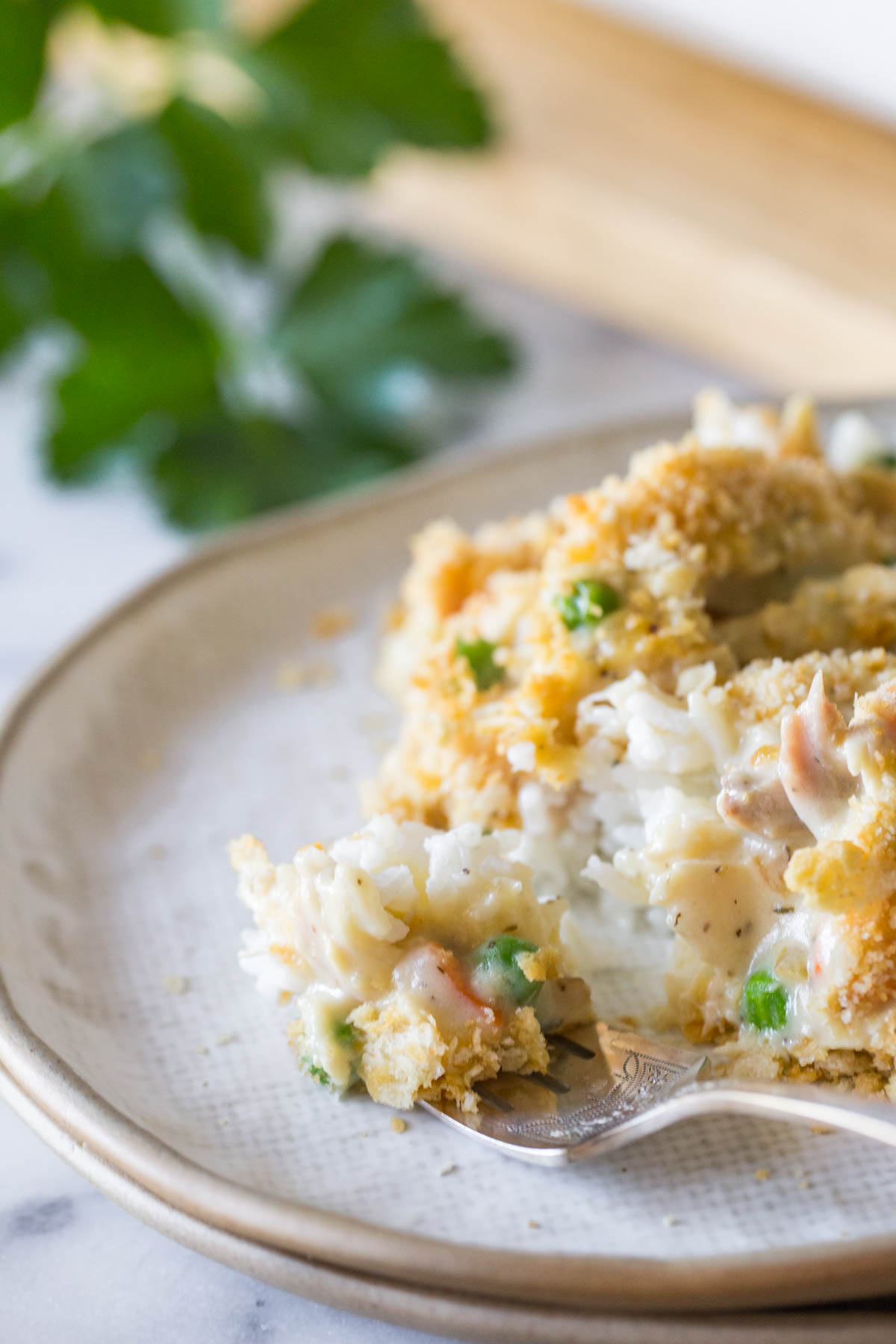 Forkful of Creamy Chicken and Rice Bake on a white plate. 