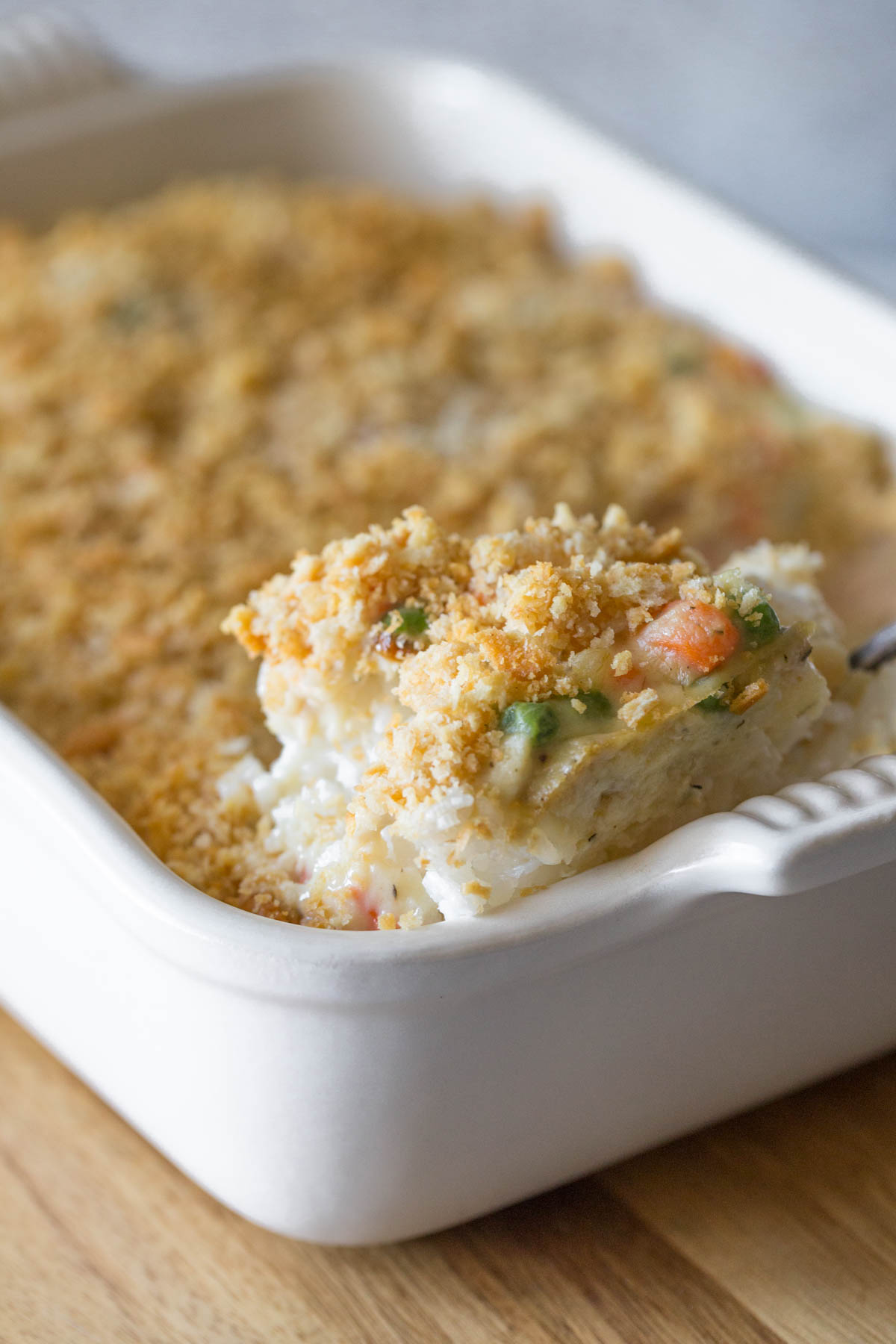 Close up view of Creamy Chicken and Rice Bake spooned out of the white casserole dish.  