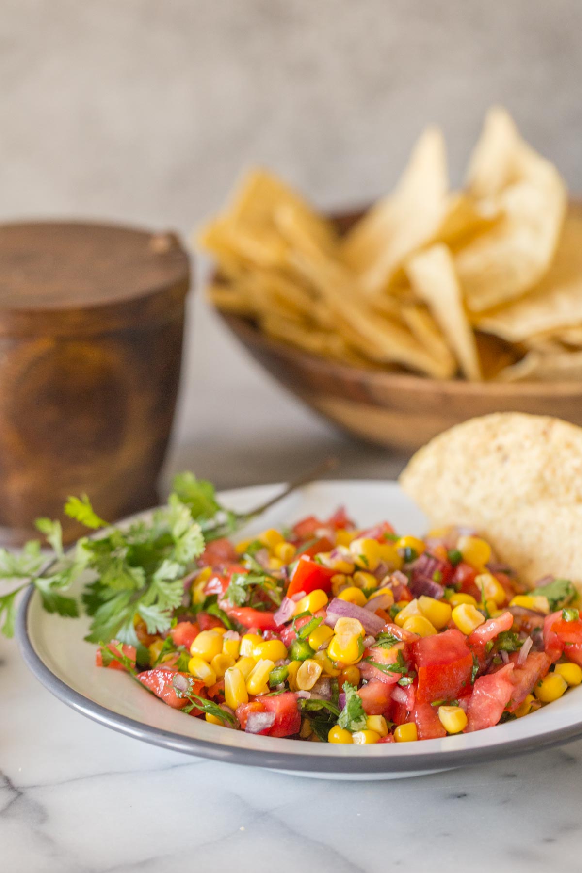 Close up of Homemade Pico de Gallo in a white bowl with chips. 