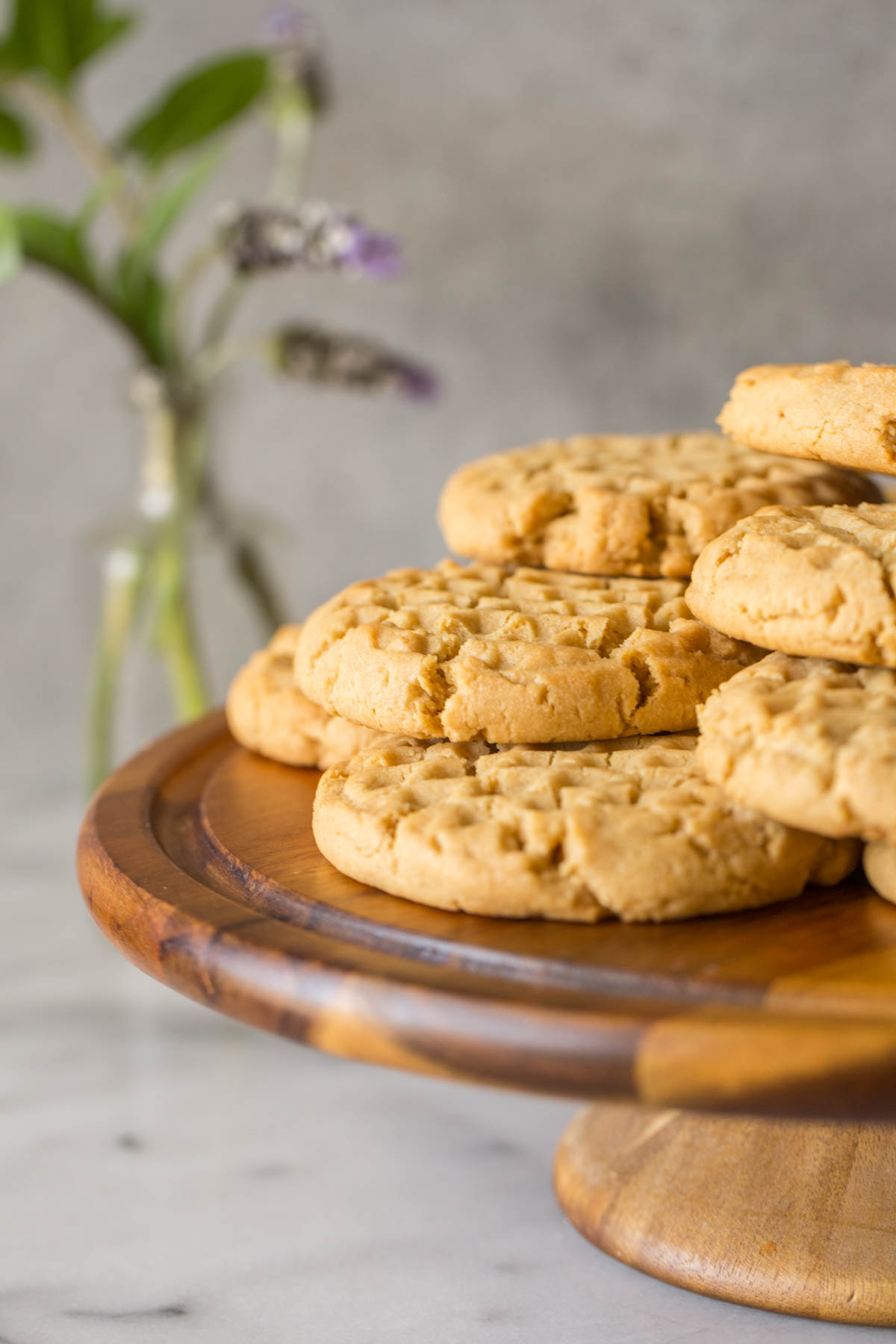 Close up view of Soft and Chewy Peanut Butter Cookies on a cake stand with a grey background. 