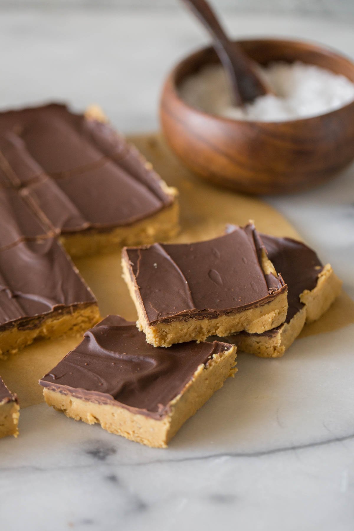 Cut bars of Chocolate Peanut Butter Bars on a piece of parchment paper. 
