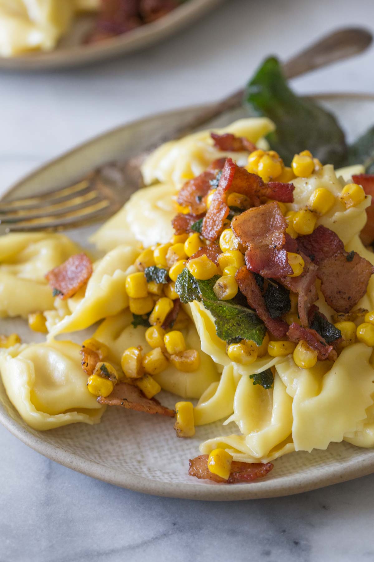 Close up shot of Creamy Tortellini With Bacon and Corn.  