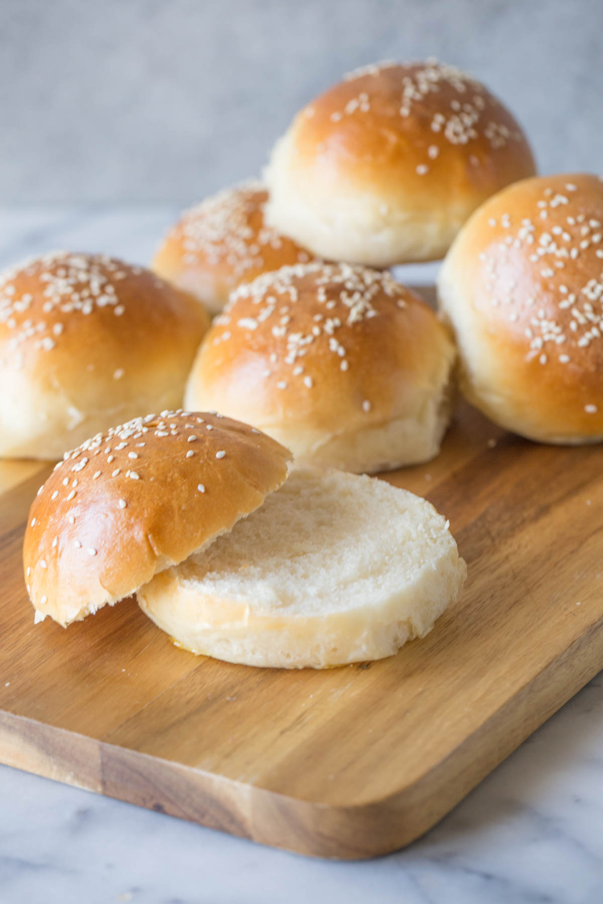 Sourdough Hamburger Buns on a wooden cutting board.