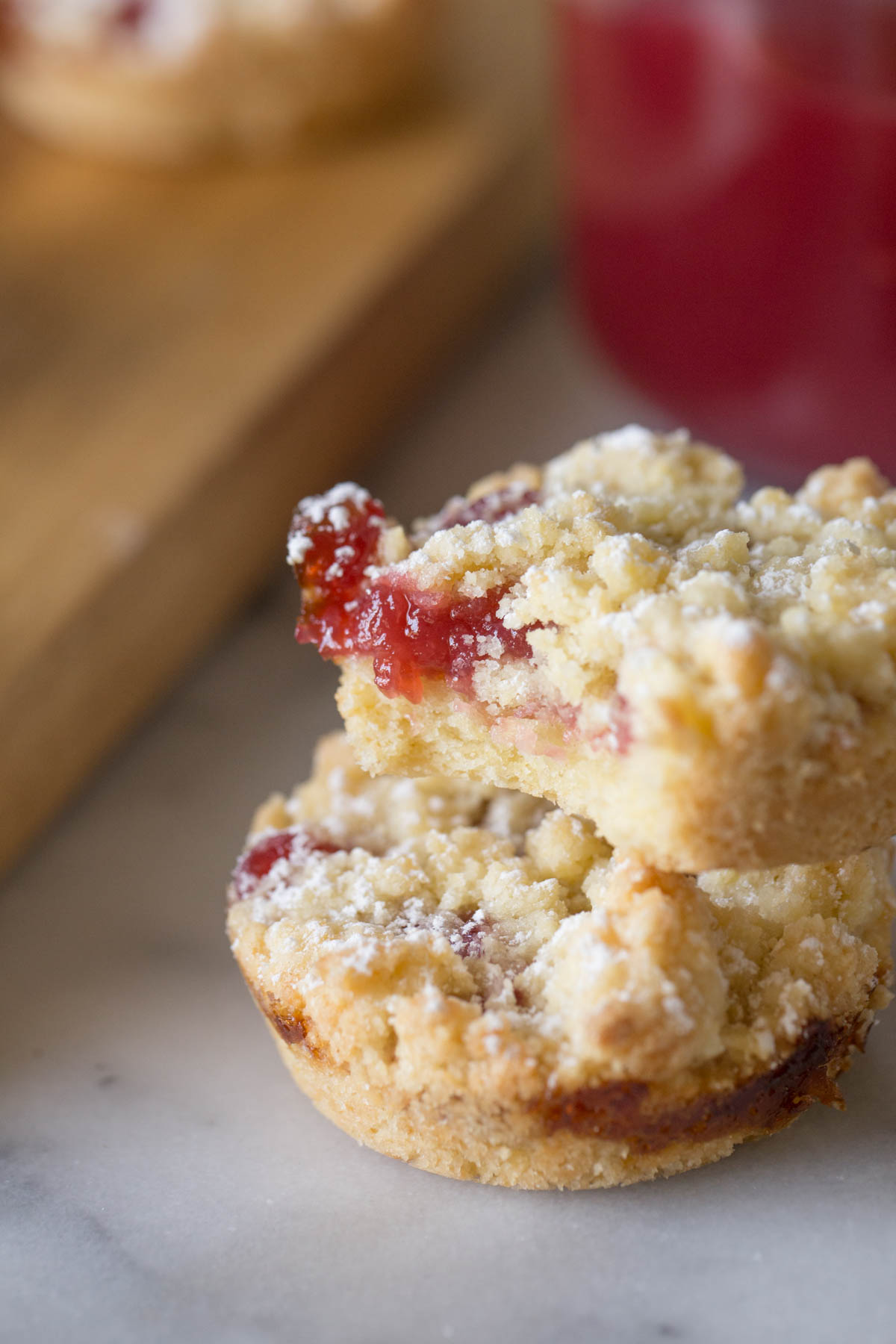 Close up shot of two Costco Raspberry Crumble Cookies, one with a bite missing, showing the inside texture of the cookie.  