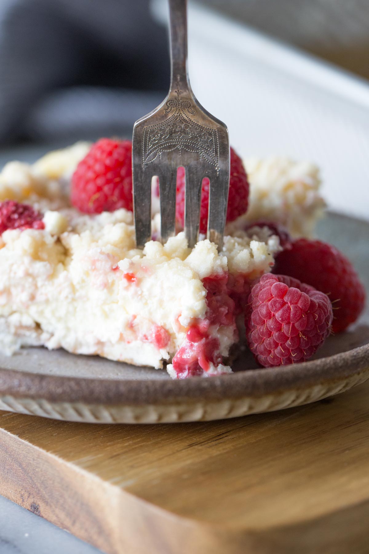 Close up shot of a fork in a Cheesecake Bar With Berry Streusel on a plate. 
