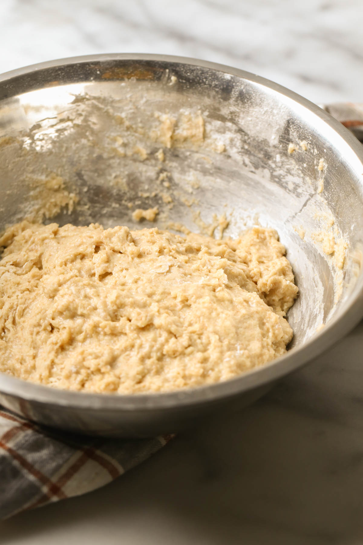 A mixing bowl with the dough for the Overnight Honey Wheat Rolls. 