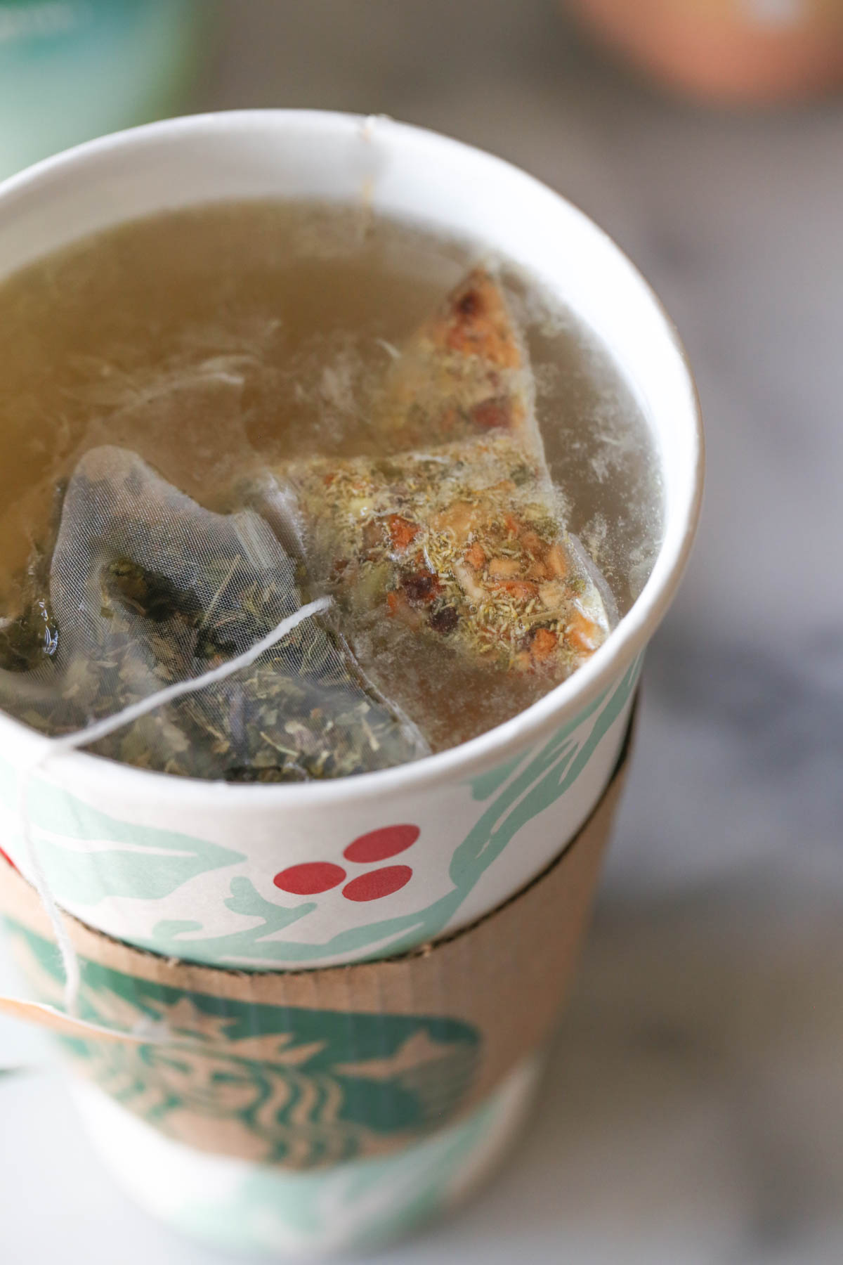 Close up shot of Starbucks Medicine Ball Tea in a Starbucks hot cup, with the tea bags floating on top.  