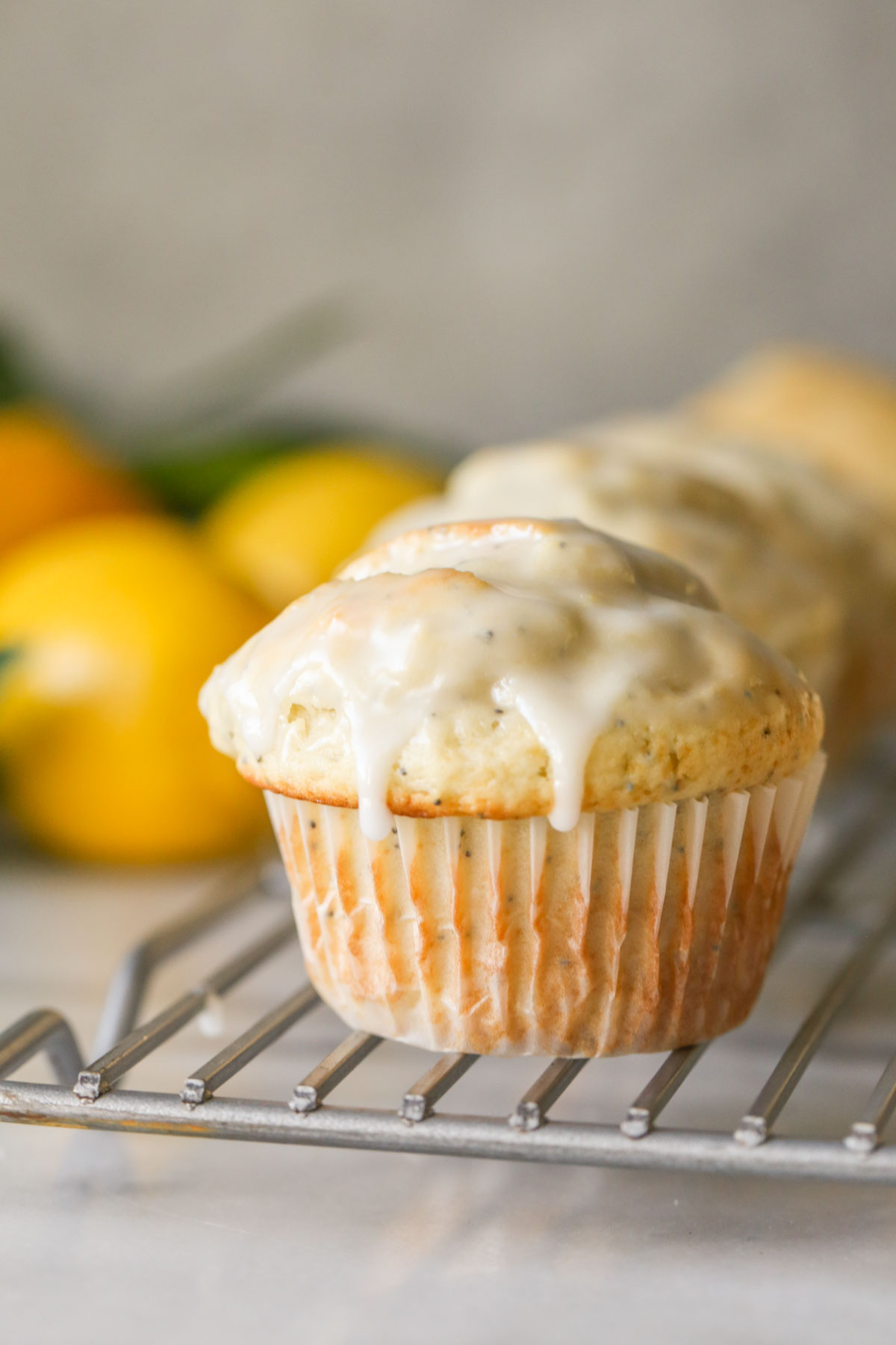 Close up shot of a Glazed Lemon Poppy Seed Muffin on a cooling rack.  