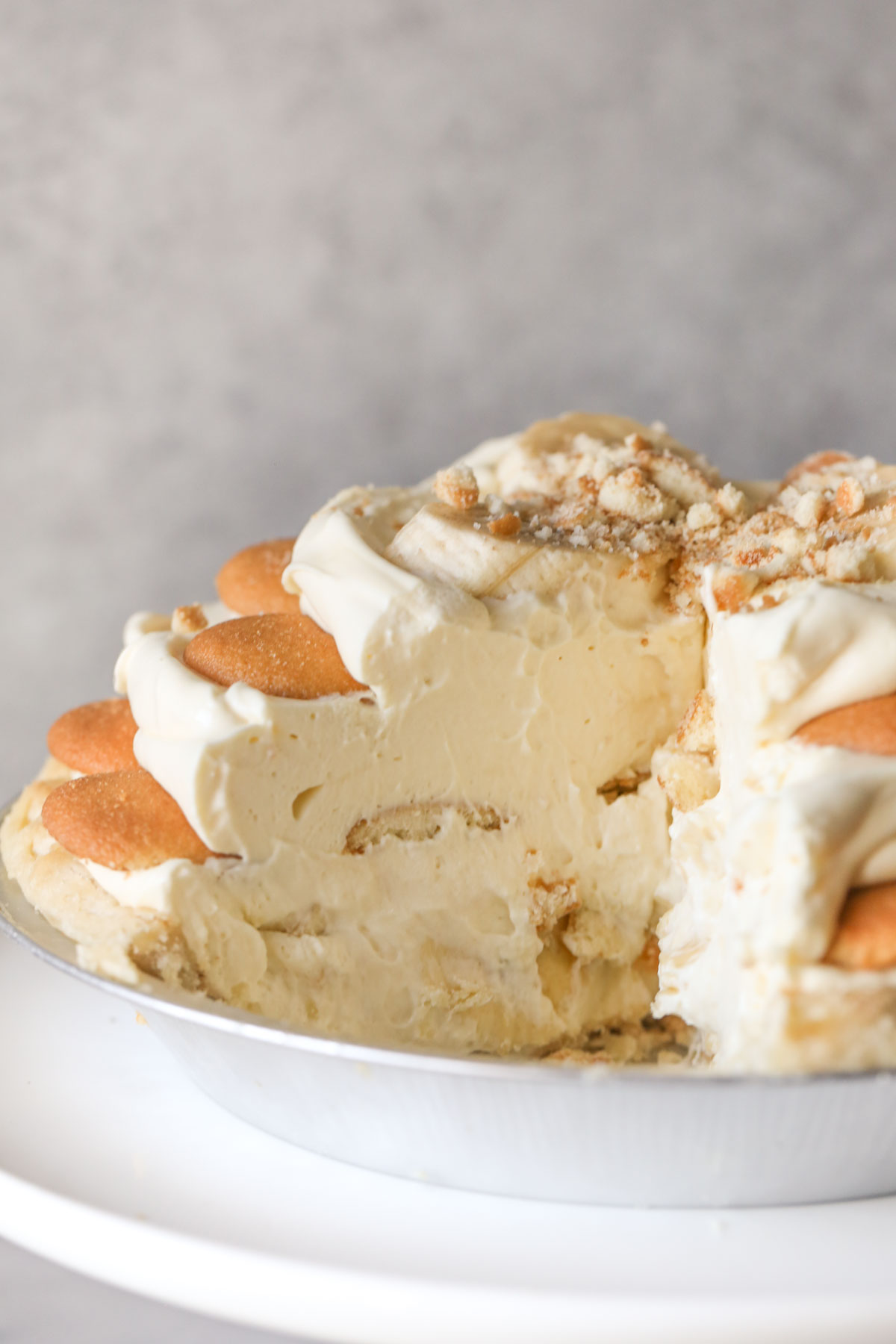 Close up shot of Mile High Banana Pudding Pie with a slice cut out, showing the inside layers of the pie.  