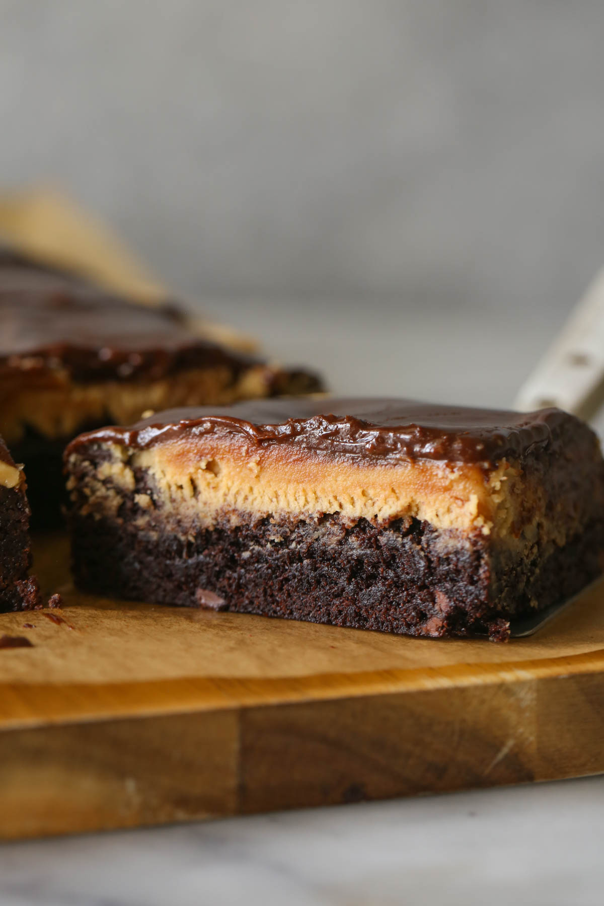 Close up shot of a cut piece of Chocolate Peanut Butter Brownie, showing the three layers.  