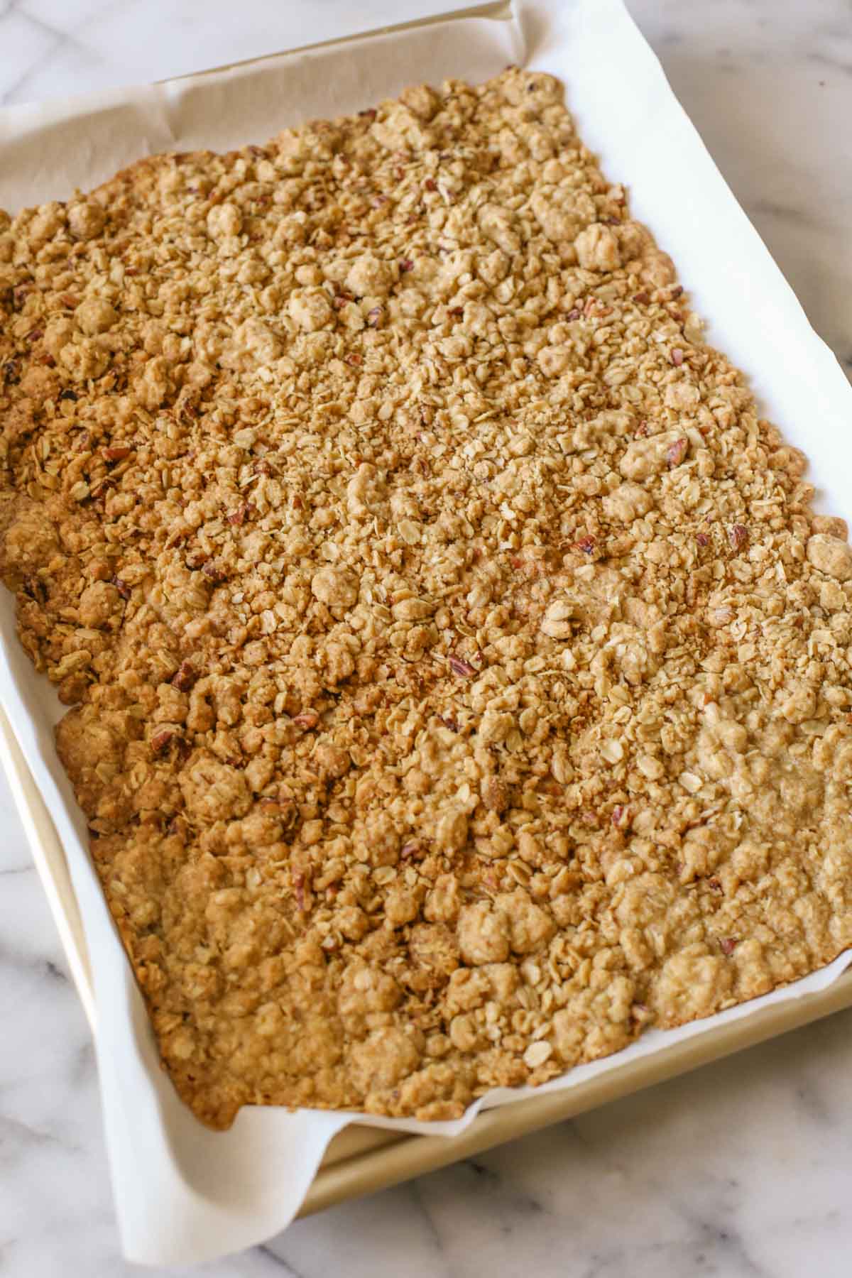 The crisp for the White Chocolate Raspberry Crisp Ice Cream on a parchment paper lined baking sheet.  