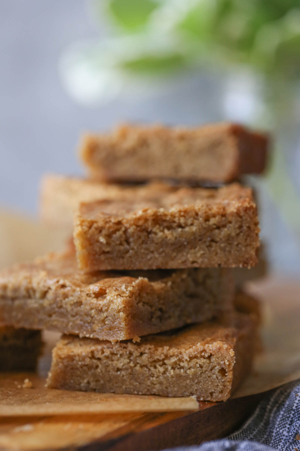 Close up shot of a stack of three Best Ever Blondies, with more blondies in the background. 